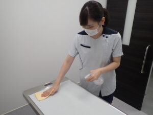 診察台をアルコール消毒しているスタッフ