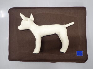 介護マットに横たわる犬の模型